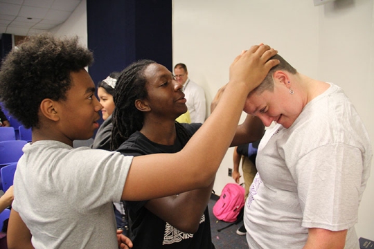 Benjamin Stoddert Middle School sixth grader Justin Tate, left, and seventh grader Reggie Johnson, check out sixth-grade reading teacher Holly Walsh’s freshly-shaved head.