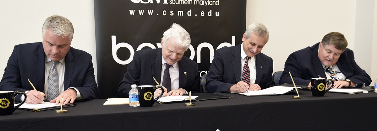 From left, Superintendent of St. Mary’s County Public Schools Scott Smith, UMUC President Javier Miyares, CSM President Dr. Brad Gottfried and NAVAIR SES 2.0 James Meade sign copies of the agreement establishing a pathway business career program.