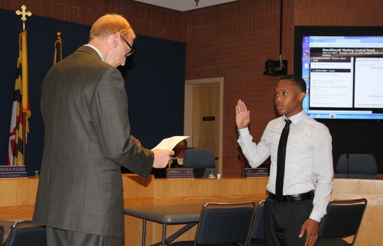 Board of Education Chairman Michael Lukas, left, swears in Drew Carter, St. Charles High School senior, as the new Student Member of the Board of Education during the Board's June 13 meeting. Carter officially begins his one-year term today and will work with a student liaison committee composed of seniors from all seven high schools throughout the school year.