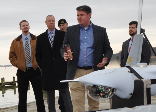 DAHLGREN, Va. (March 28, 2017) - Navy scientist Dr. Chris Weiland briefs visitors on the coordinated use of unmanned aerial vehicles for intelligence and targeting at a demonstration of the Surface and Expeditionary Warfare Mission Module that will be integrated in the developmental Common Unmanned Surface Vehicle (CUSV). The mission module comprises engagement system technology developed by Naval Surface Warfare Center Dahlgren Division coupled with a Battle Management System that controls munitions such as the Longbow Hellfire Missile. The event comes on the heels of a cooperative research and development agreement that NSWCDD signed with Textron Systems who makes the CUSV. The agreement covers the integration of missile, designator, and remote weapon station payloads to the CUSV with its 3,500-pound payload capacity on the deck and a payload bay measuring 20.5 x 6.5 feet. (U.S. Navy photo/Released)