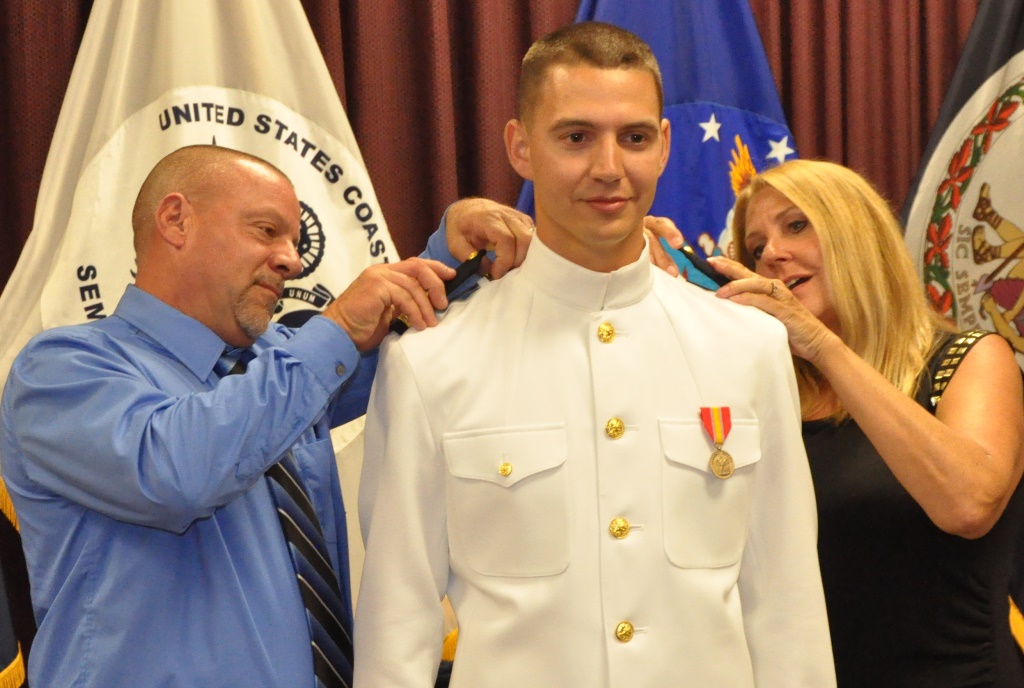 DAHLGREN, Va. (Sept. 11, 2018) --- U.S. Navy Ensign Dillard Patton's parents, Dale and Sharon, place officer shoulder boards on their son's uniform at his commissioning ceremony held at the Aegis Training and Readiness Center. The NSWC Dahlgren Division System Safety Engineering Division civilian engineer was commissioned into the officer ranks of the Naval reserves through the Direct Commission Officer program. The newly commissioned officer expressed a special appreciation to his family during the ceremony.