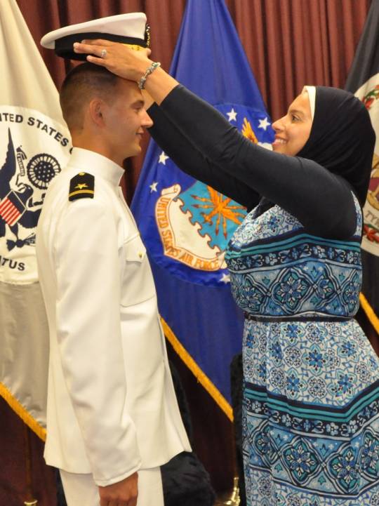 DAHLGREN, Va. (Sept. 11, 2018) --- Nourhan Ibrahim places a new officer's cover on the head of her husband, Dillard Patton, who was commissioned into the Naval reserves as an ensign at a ceremony held at the Aegis Training and Readiness Center.