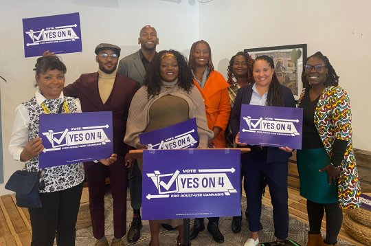 Former Baltimore Ravens player Eugene Monroe, in rear, and members of Yesfor4 are urging Maryland residents to vote yes on question four on the ballot to approve legalization of recreational cannabis when they go to the polls Nov. 8.